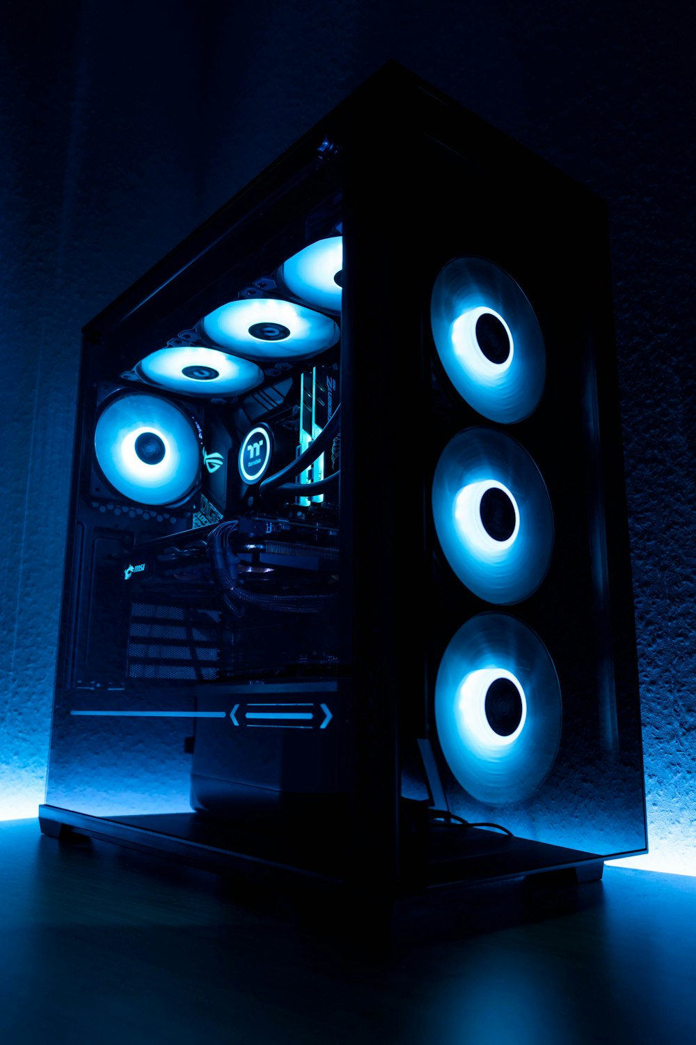 A gaming PC lit with pink and purple RGB lighting
